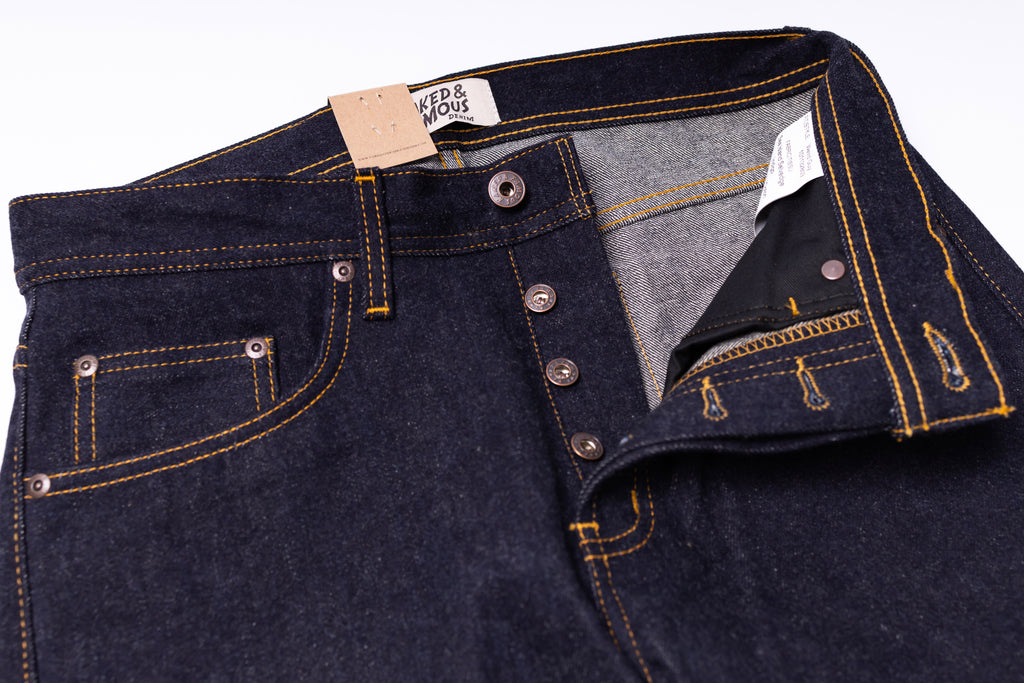 Close-up of dark blue jeans with a button and zipper, on a white background