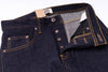 Close-up of dark blue jeans with a button and zipper, on a white background