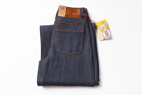 Folded pair of jeans with a tag on a white background