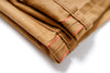 Folded brown fabric with red stitching on a white background