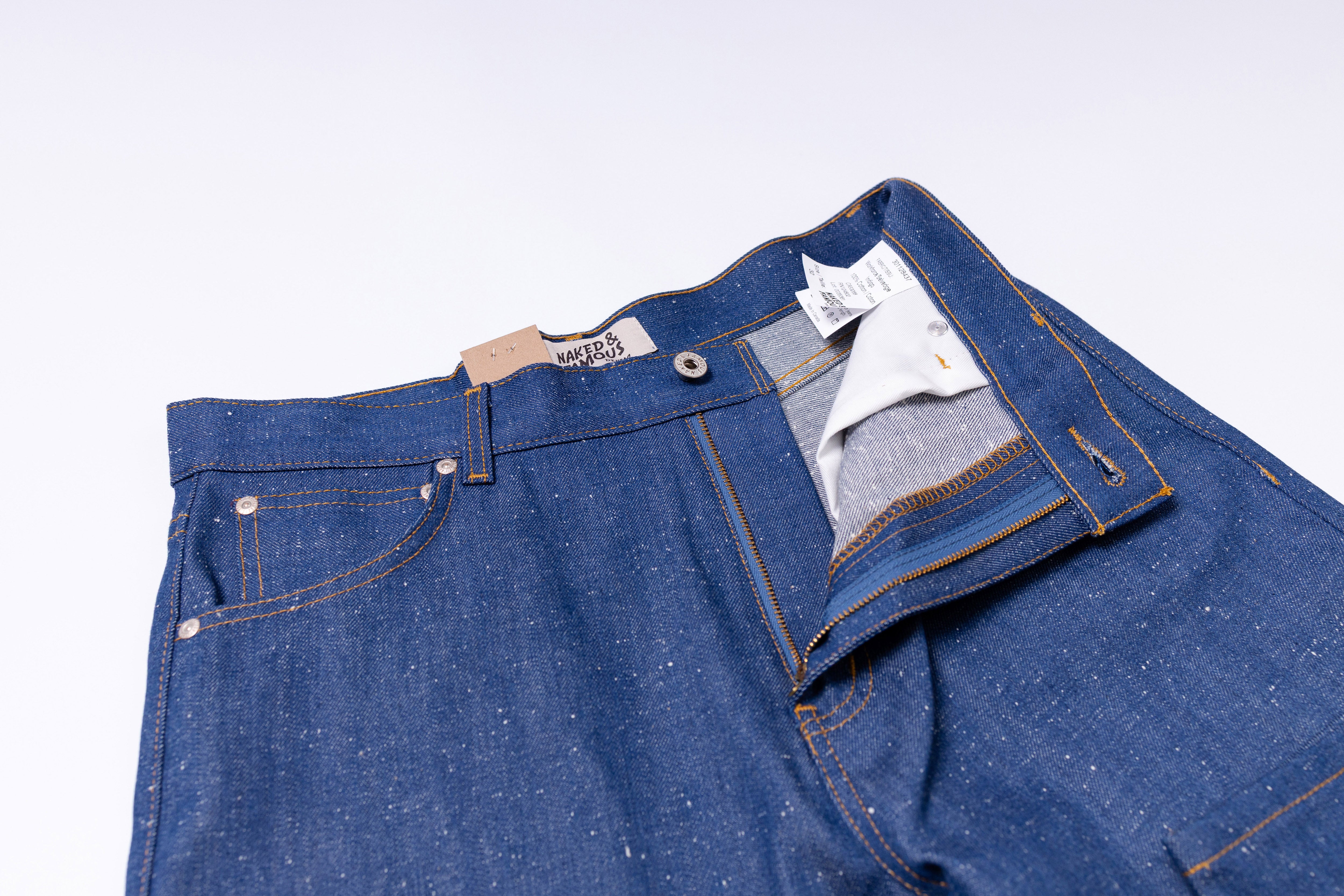Blue denim jeans with a brand label on a light gray background