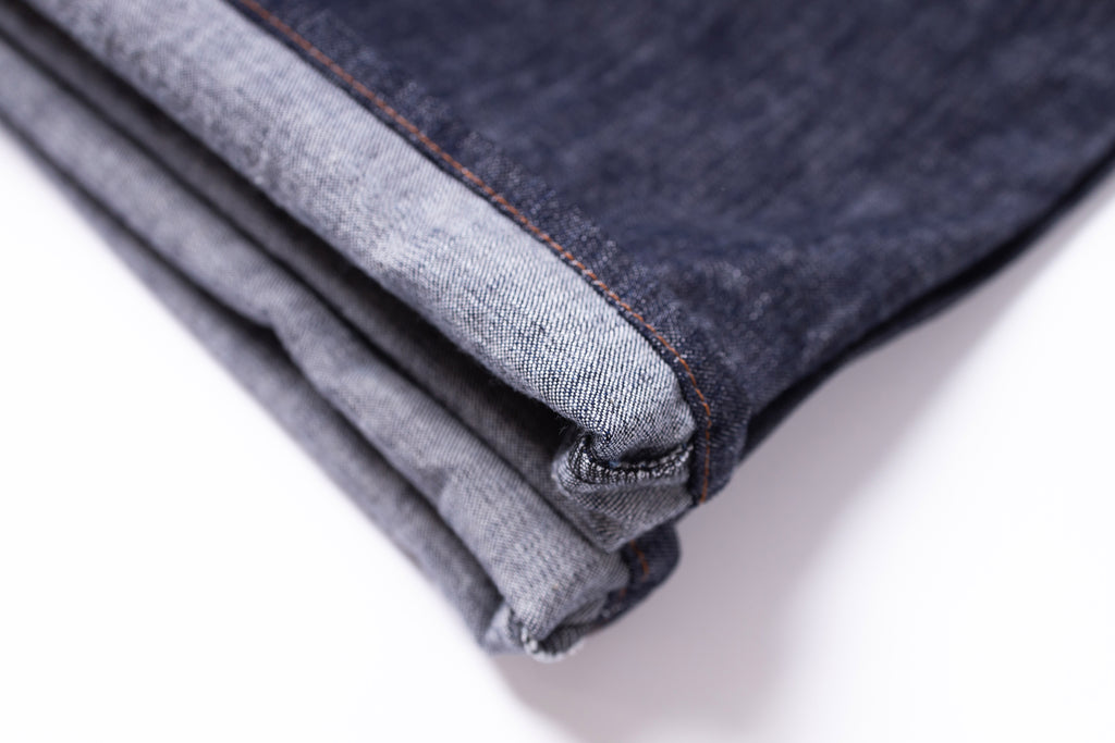 Folded denim jeans on a white background