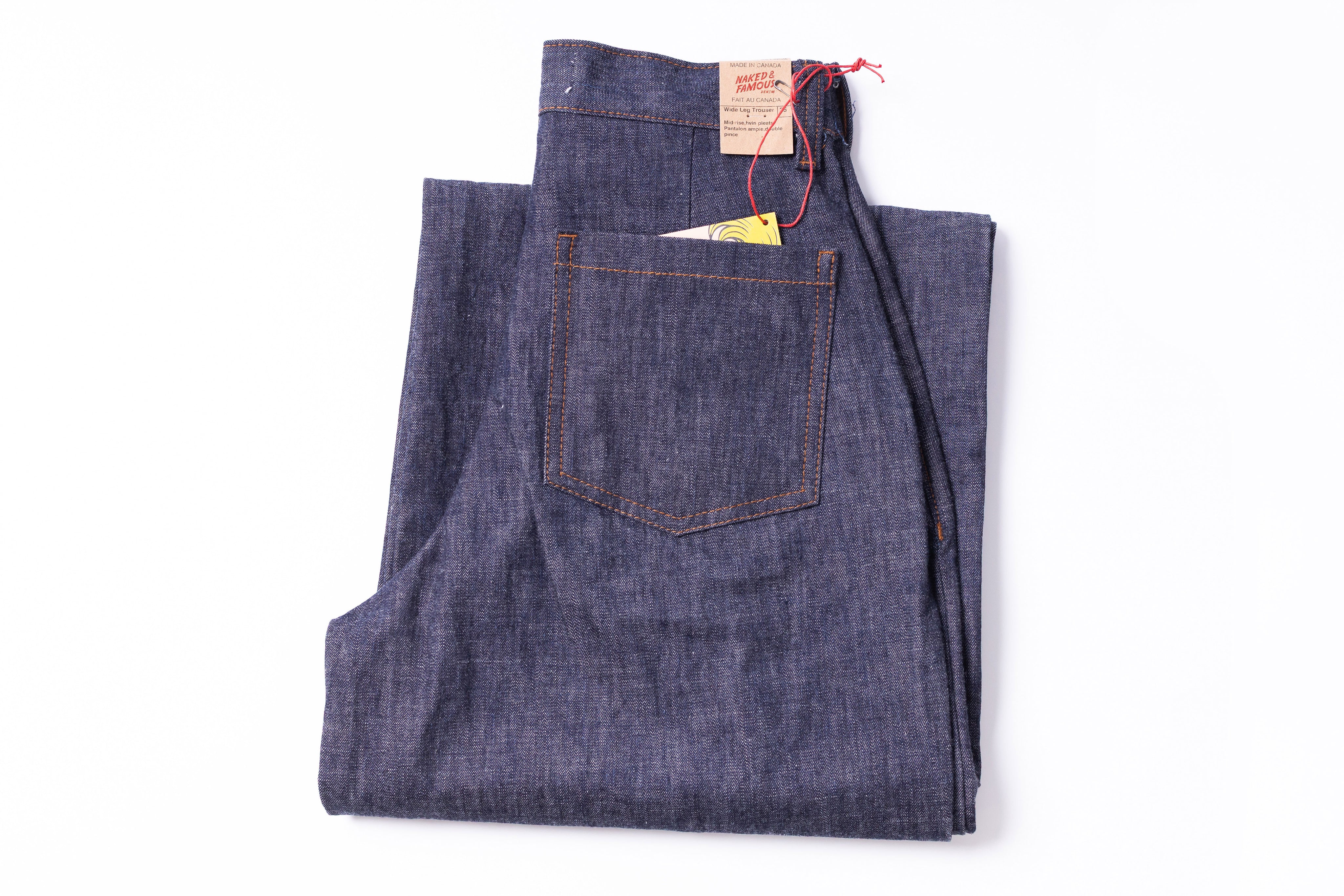 Folded pair of blue jeans with a brand label on a white background