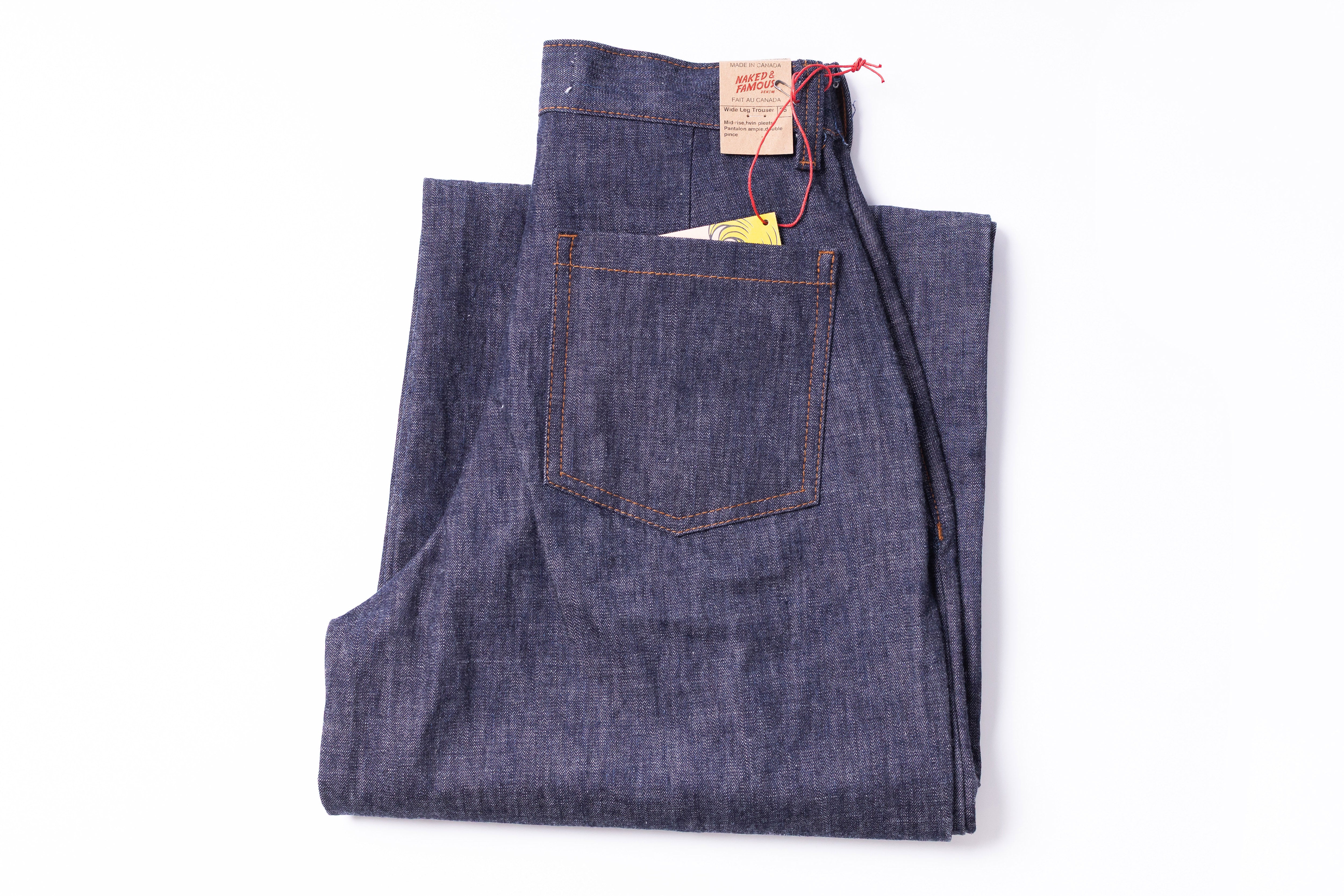 Folded pair of blue jeans with a brand label on a white background