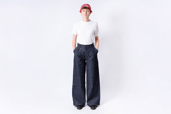 Person wearing a white shirt and dark blue wide-leg pants on a white background
