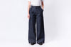 Person wearing dark blue wide-leg jeans on a white background