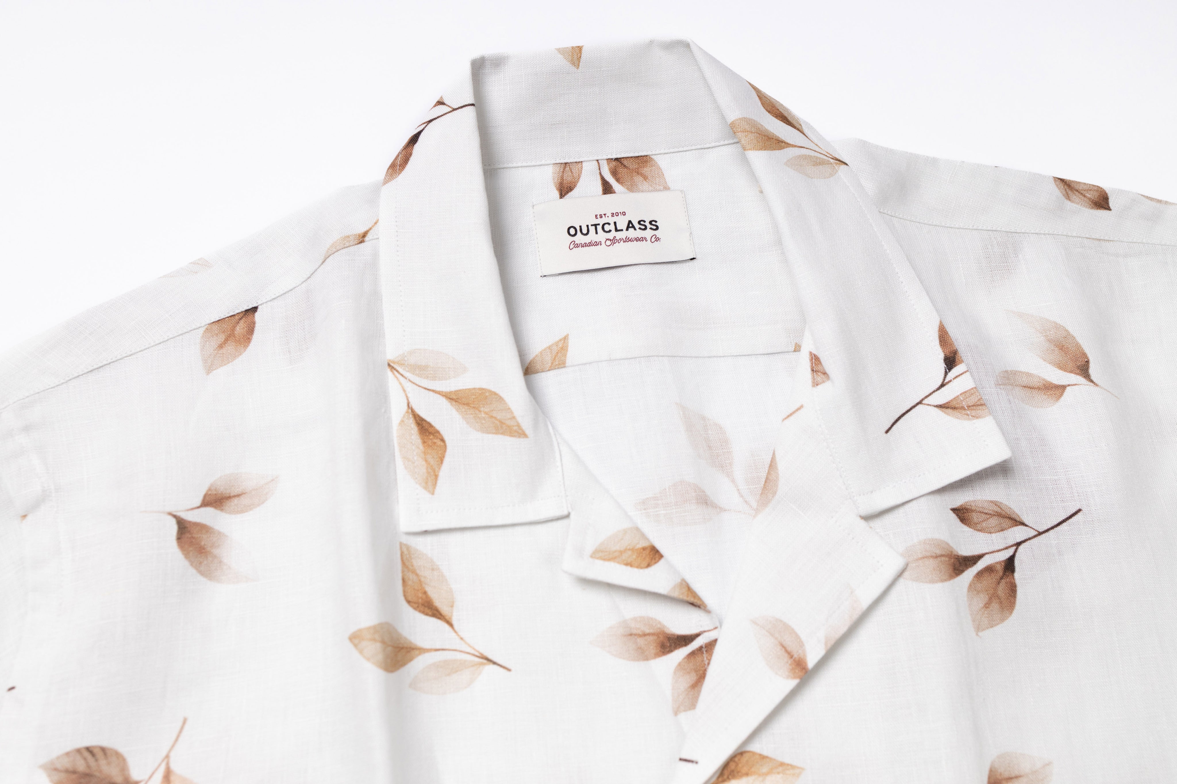 White shirt with leaf pattern and Outclass label on a white background