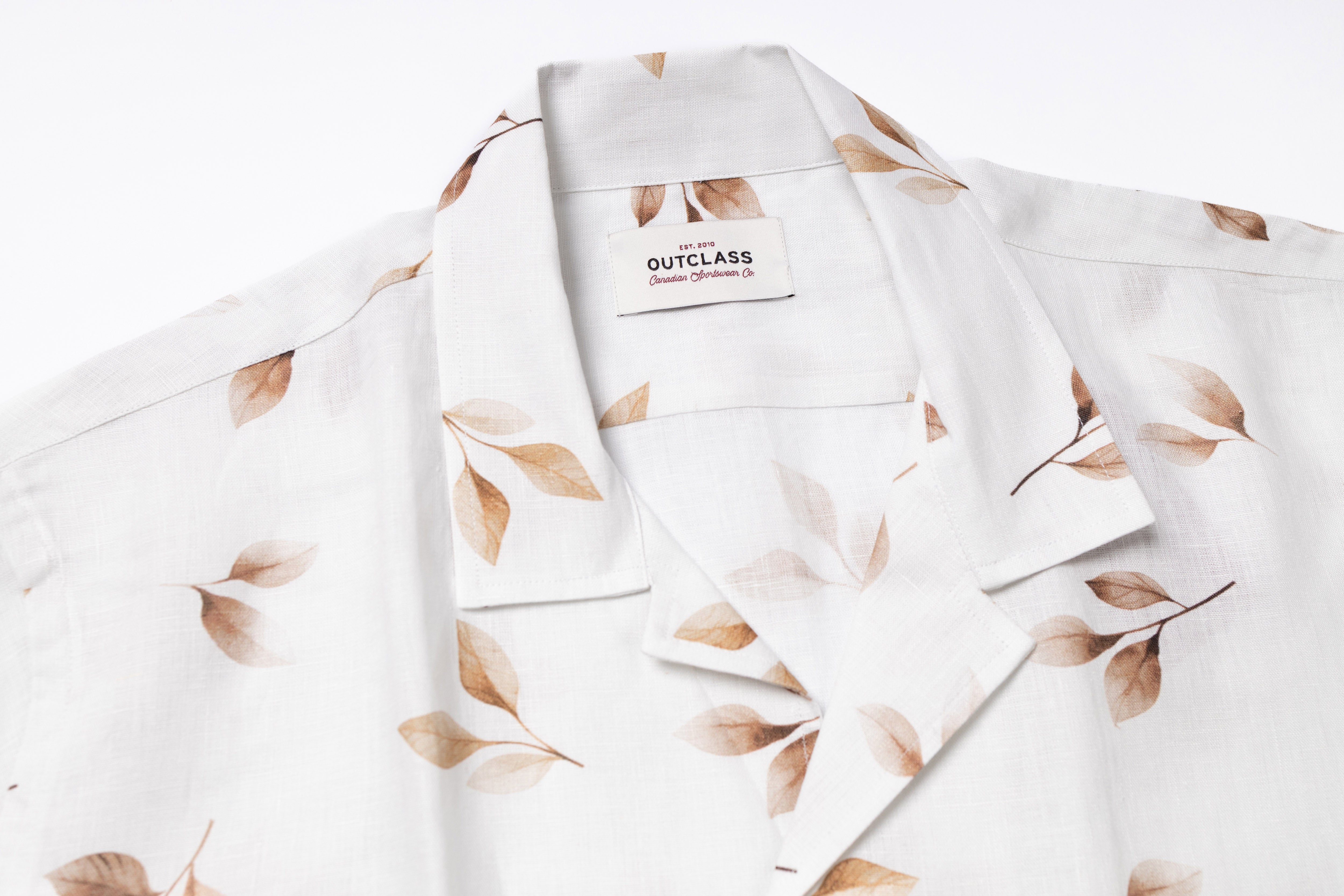 White shirt with leaf pattern and Outclass label on a white background