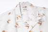 White shirt with leaf pattern and Outclass label on a white background