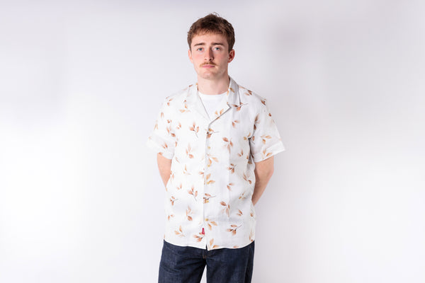 Man wearing a white floral shirt against a plain background