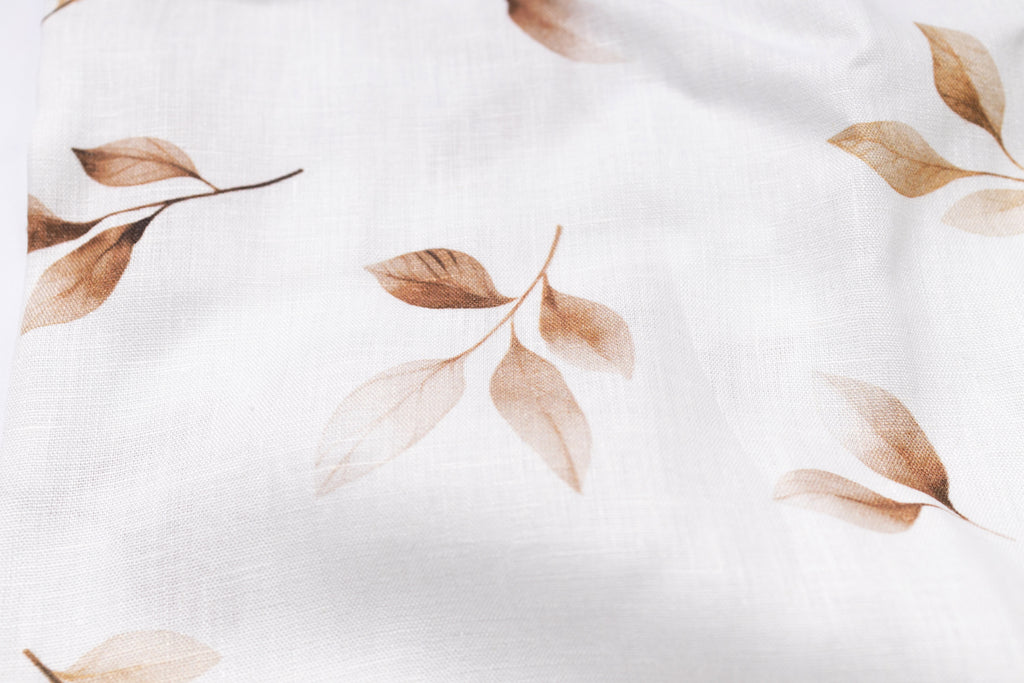 Close-up of fabric with brown leaf pattern on a white background