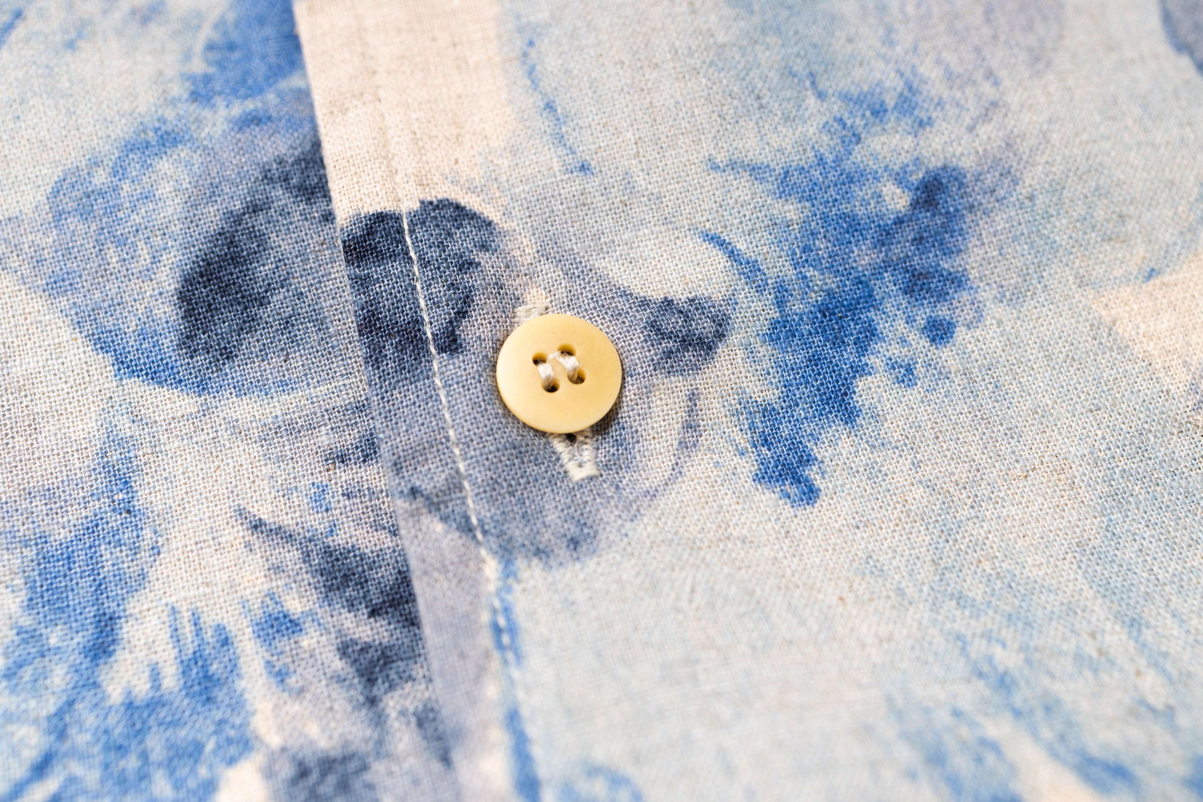 Close-up of a button on a blue and white fabric background