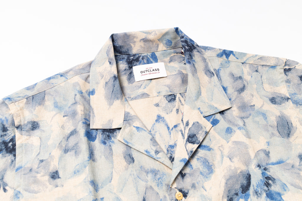Blue and white patterned shirt with a brand label on a white background