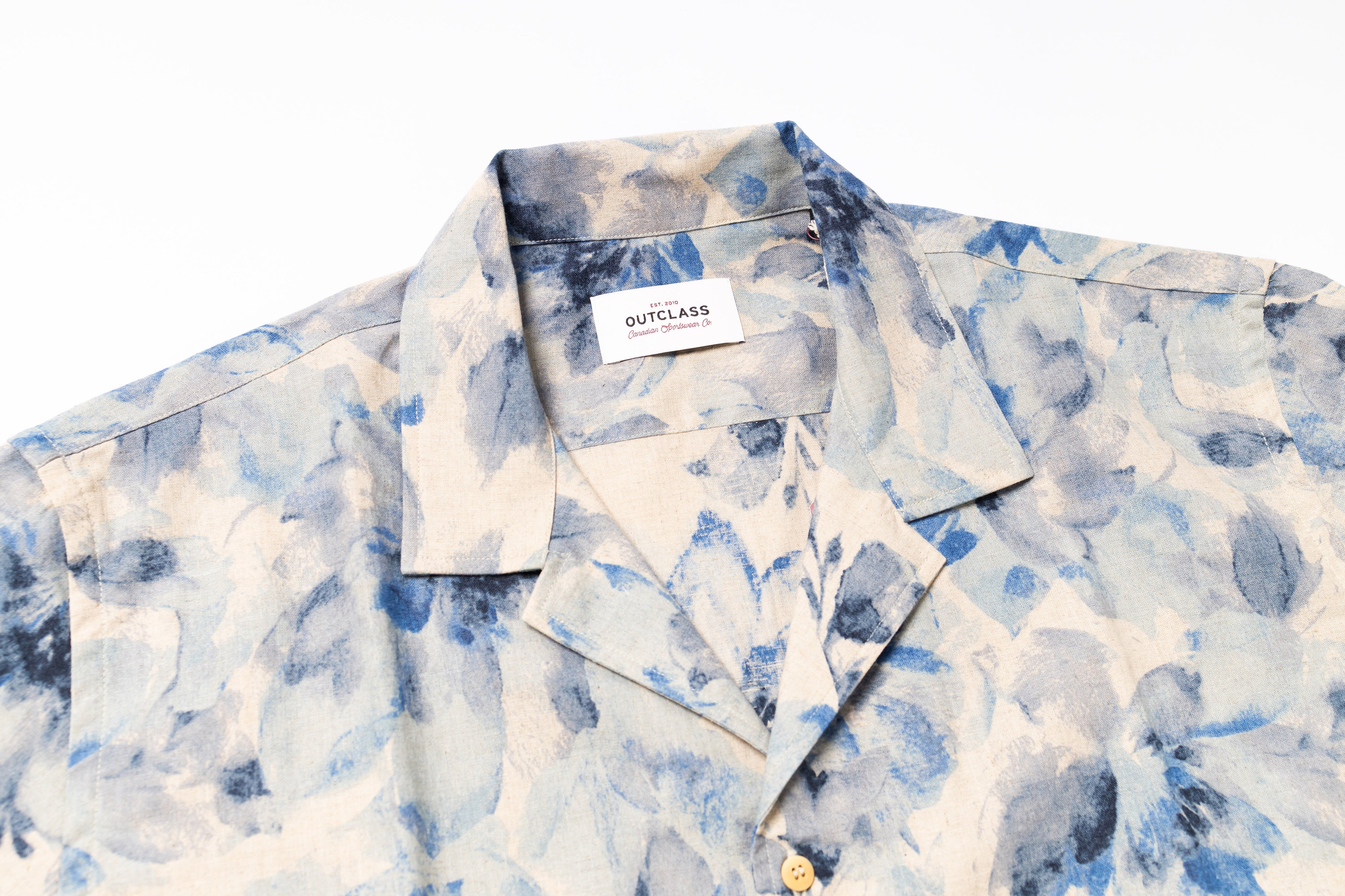 Blue and white patterned shirt with a brand label on a white background