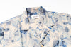 Blue and white patterned shirt with a brand label on a white background