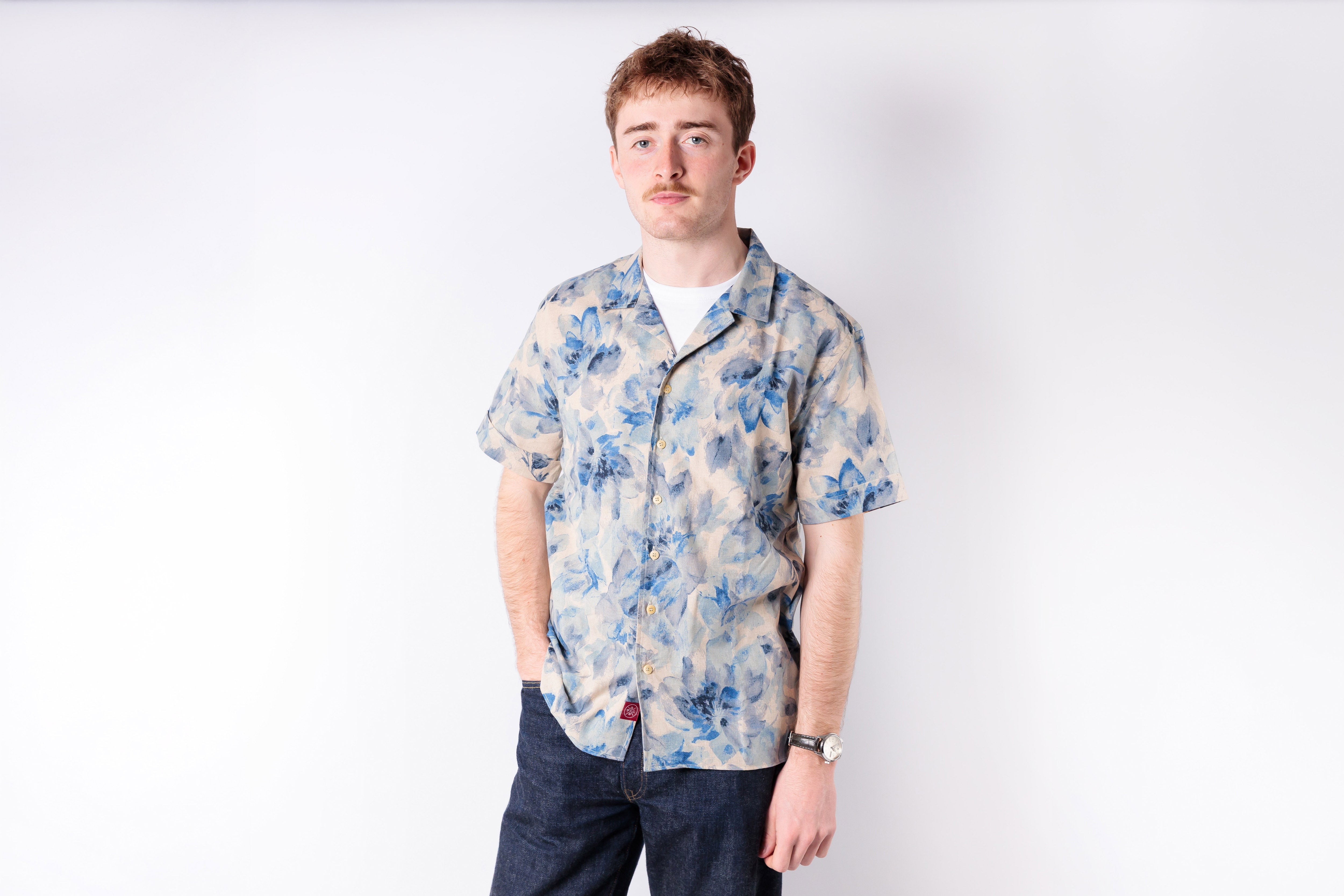 Man wearing a floral shirt on a white background