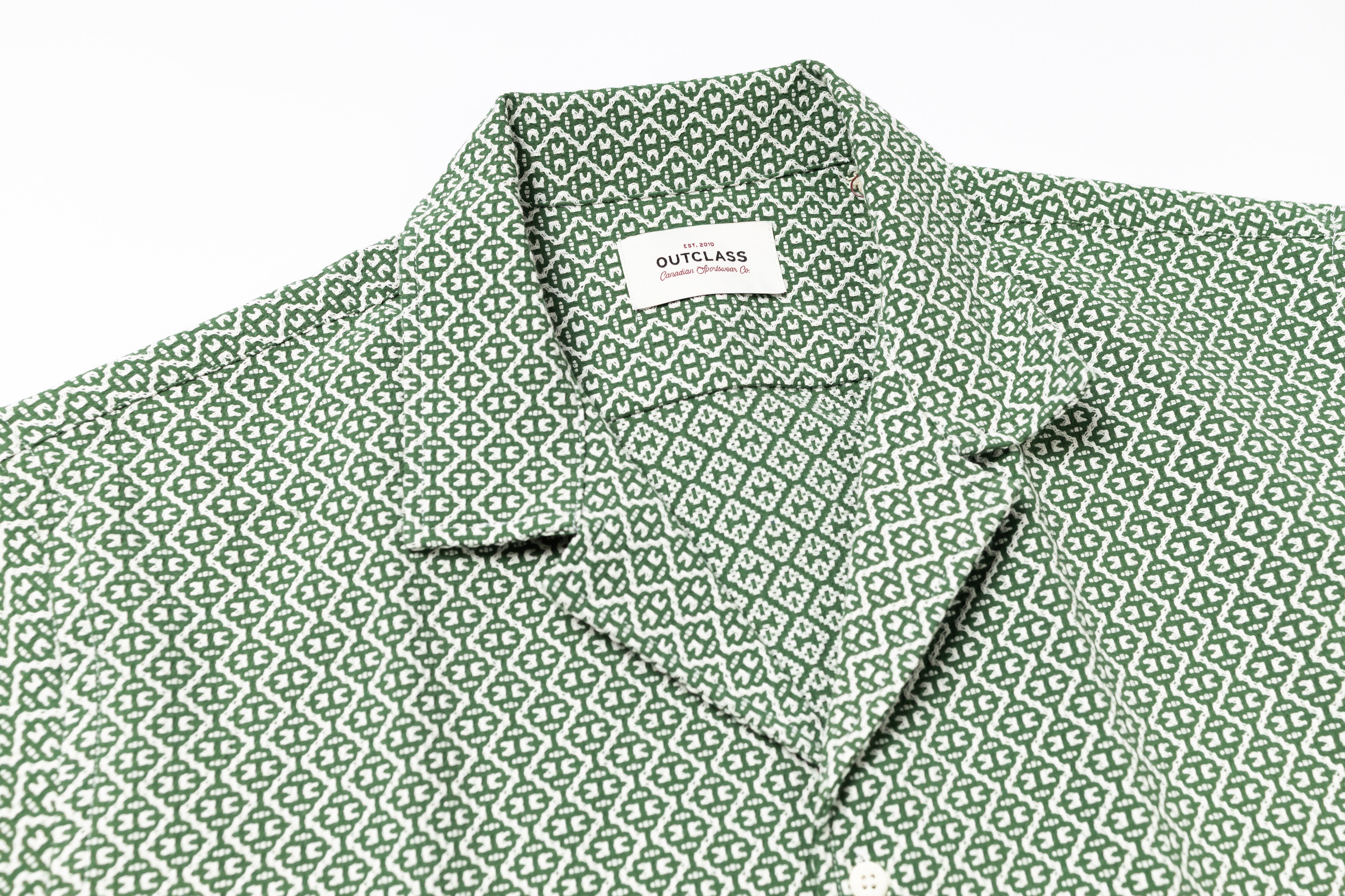 Green patterned shirt with a brand label on a white background