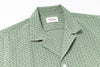Green patterned shirt with a brand label on a white background