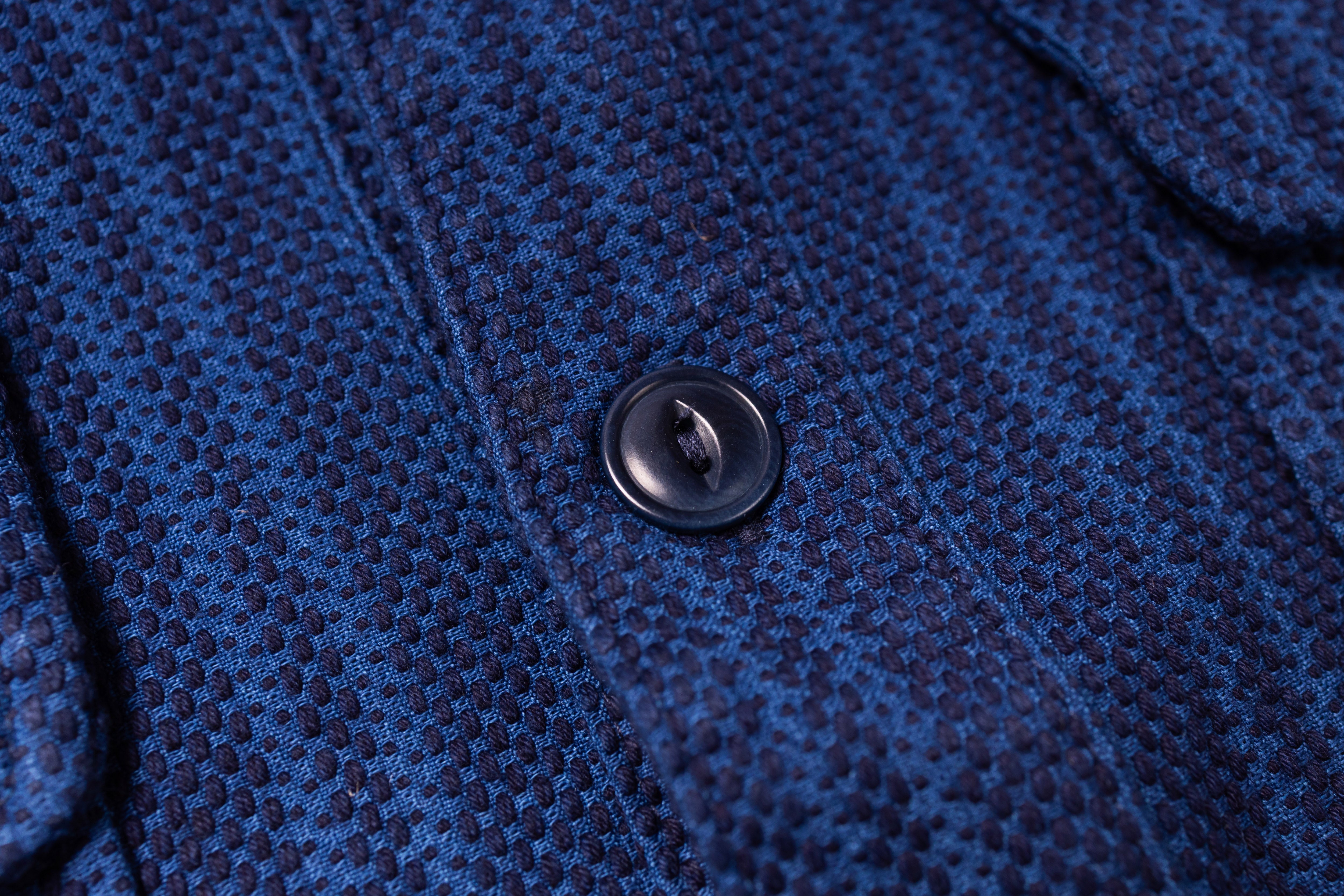 Close-up of a blue textured fabric with a button