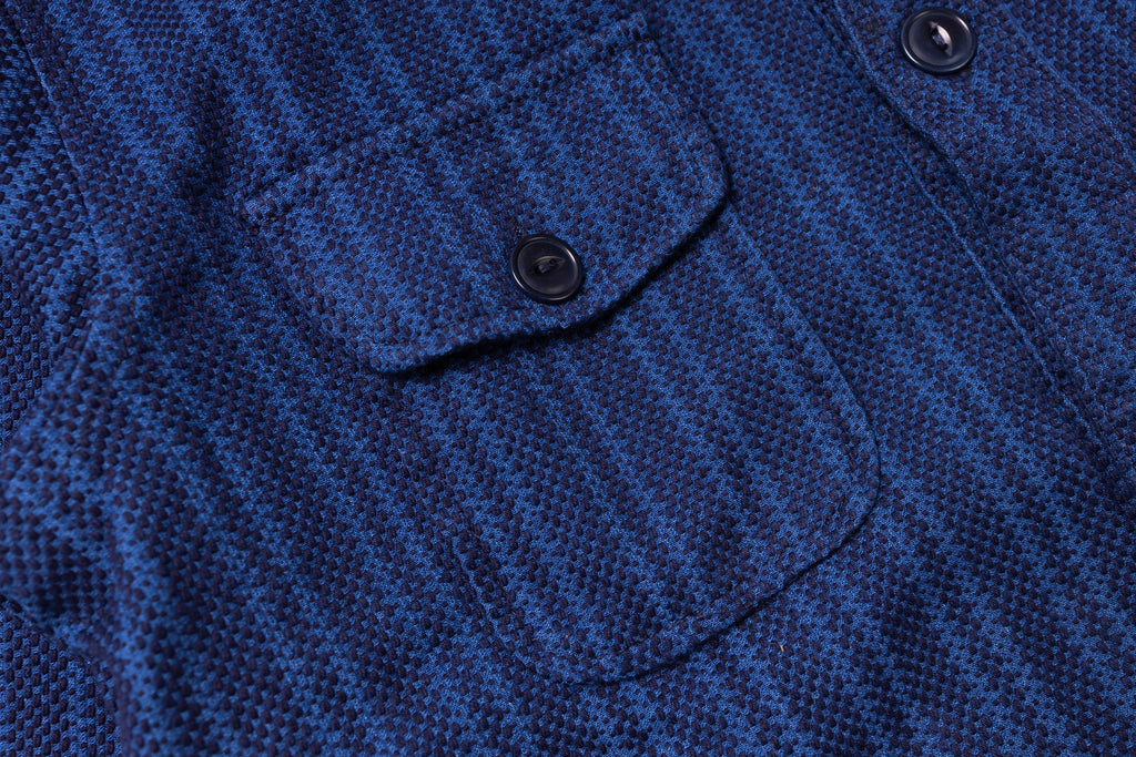 Close-up of a blue textured fabric with a button