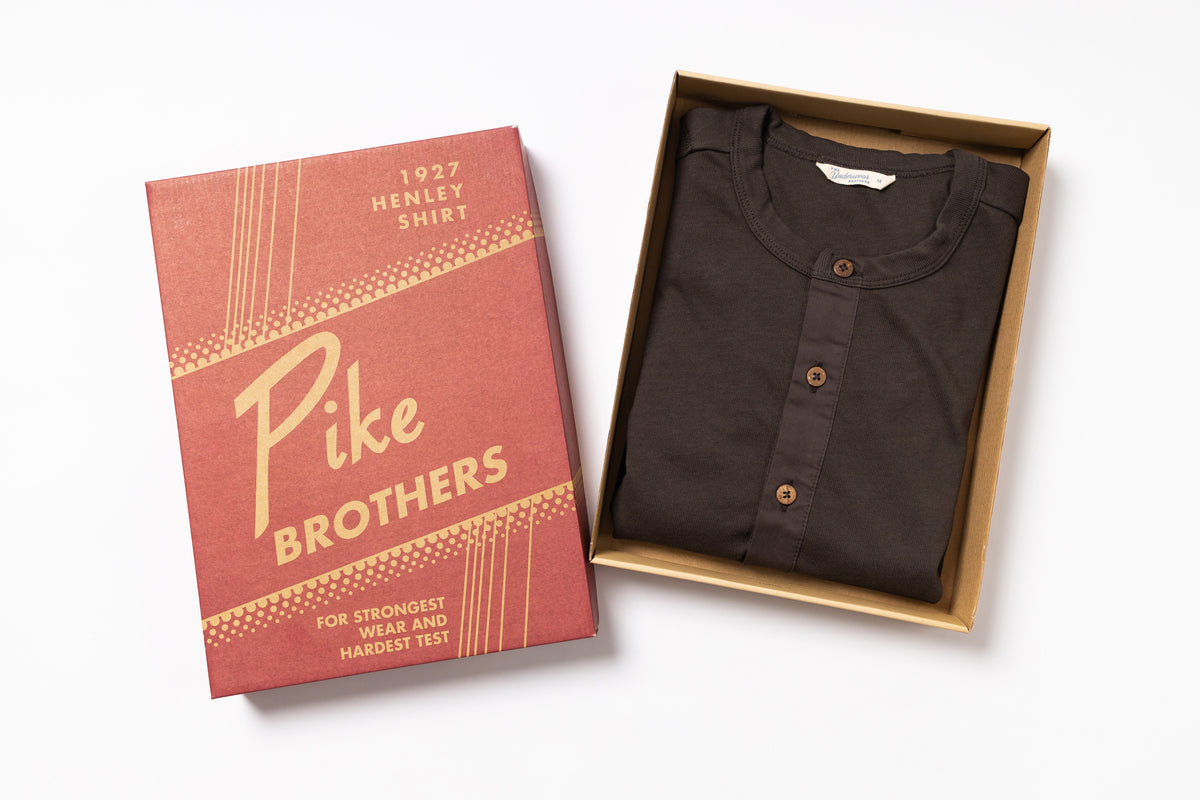 Brown henley shirt in a box with Pike Brothers packaging on a white background