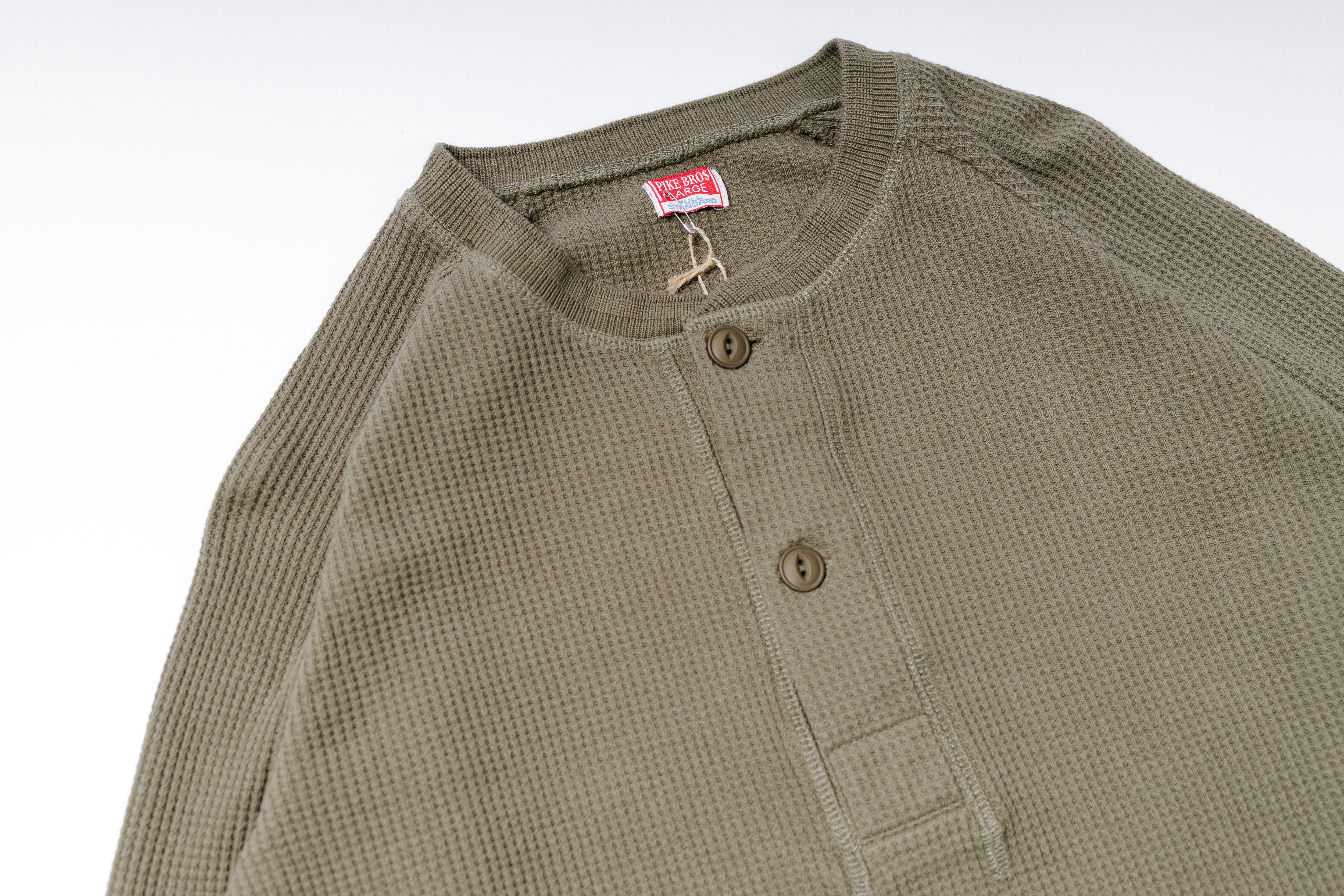 Green textured shirt with buttons on a white background