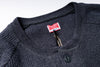 Close-up of a dark gray sweater with a brand label on a white background