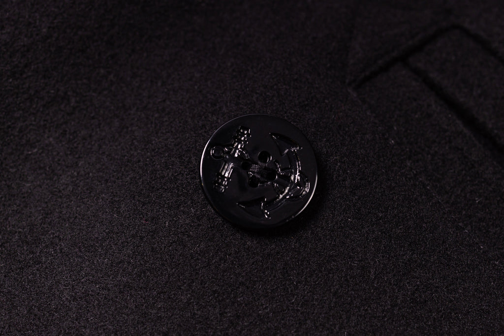 Close-up of a black button on a dark fabric background