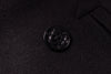 Close-up of a black button on a dark fabric background