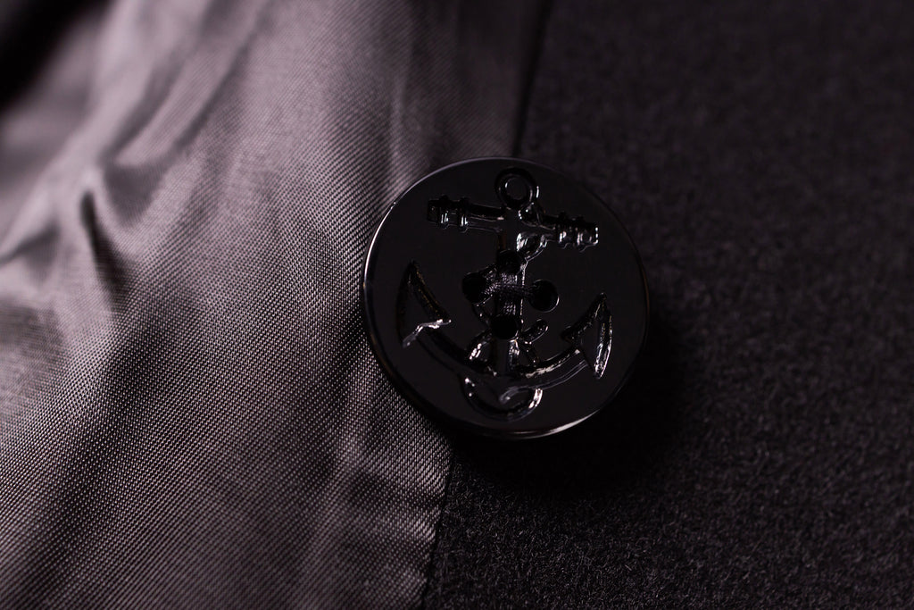 Close-up of a black button on a dark fabric background
