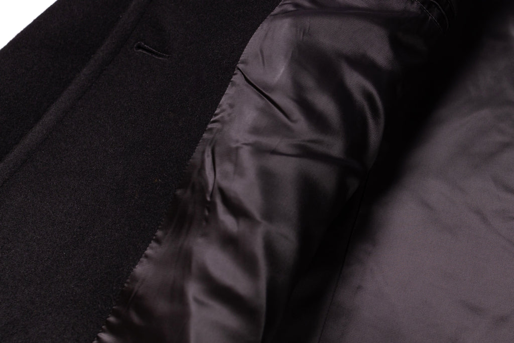 Close-up of a black coat with a focus on the fabric texture.