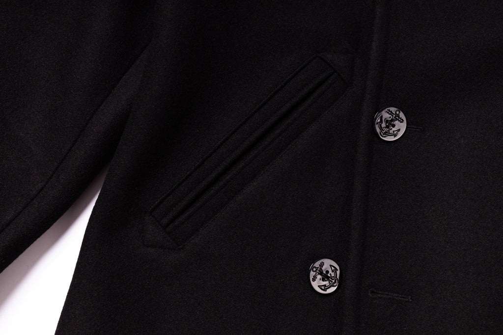 Close-up of a black coat with buttons on a white background