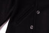 Close-up of a black coat with buttons on a white background
