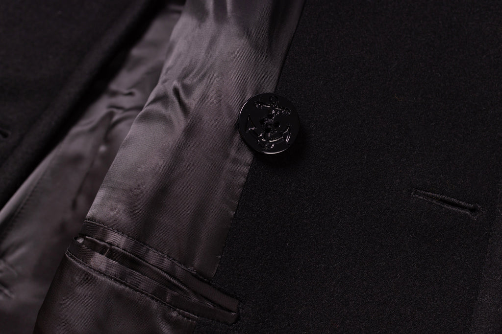 Close-up of a black button on a dark fabric surface