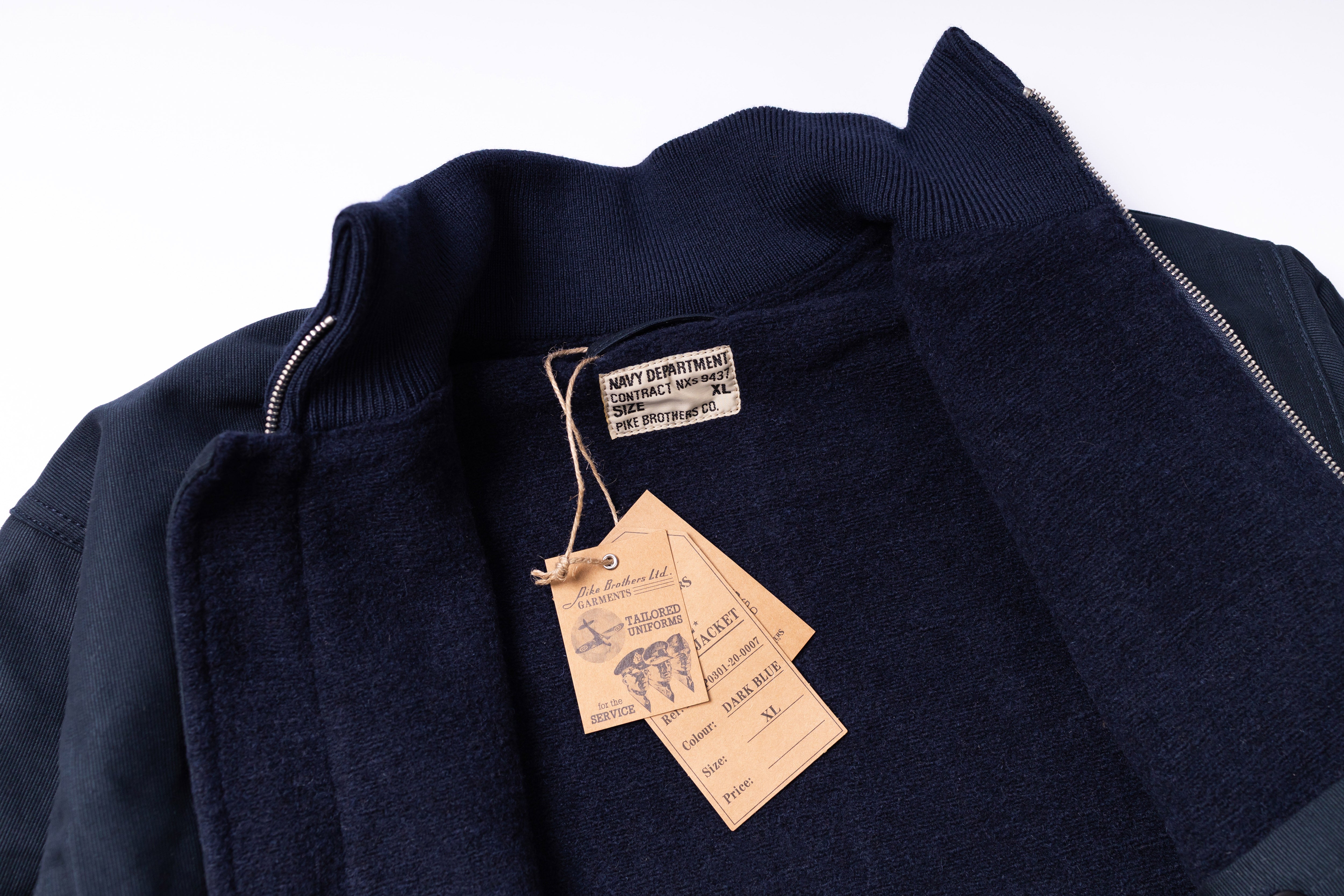 Navy jacket with tags on a white background