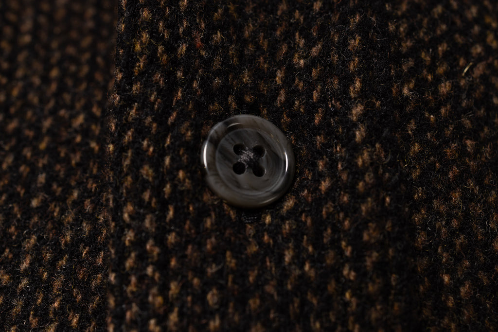 Close-up of a button on brown textured fabric