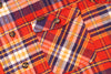 Close-up of a plaid fabric with a visible brand label.