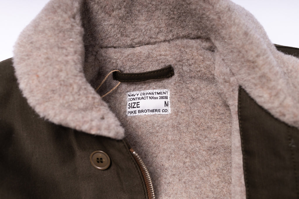 Close-up of a coat with a label on a white background