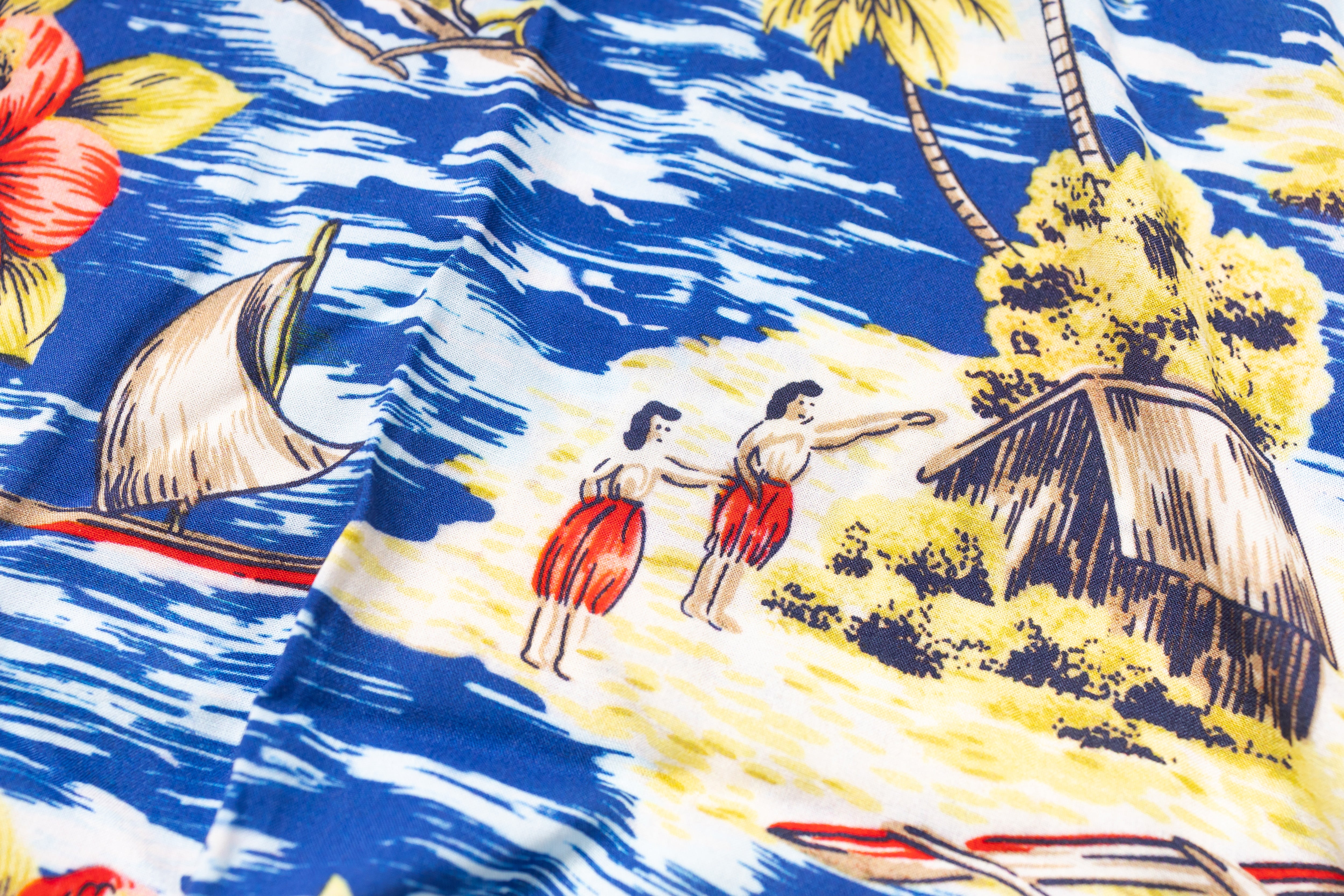 Fabric with tropical design featuring people, a hut, and sailboats.