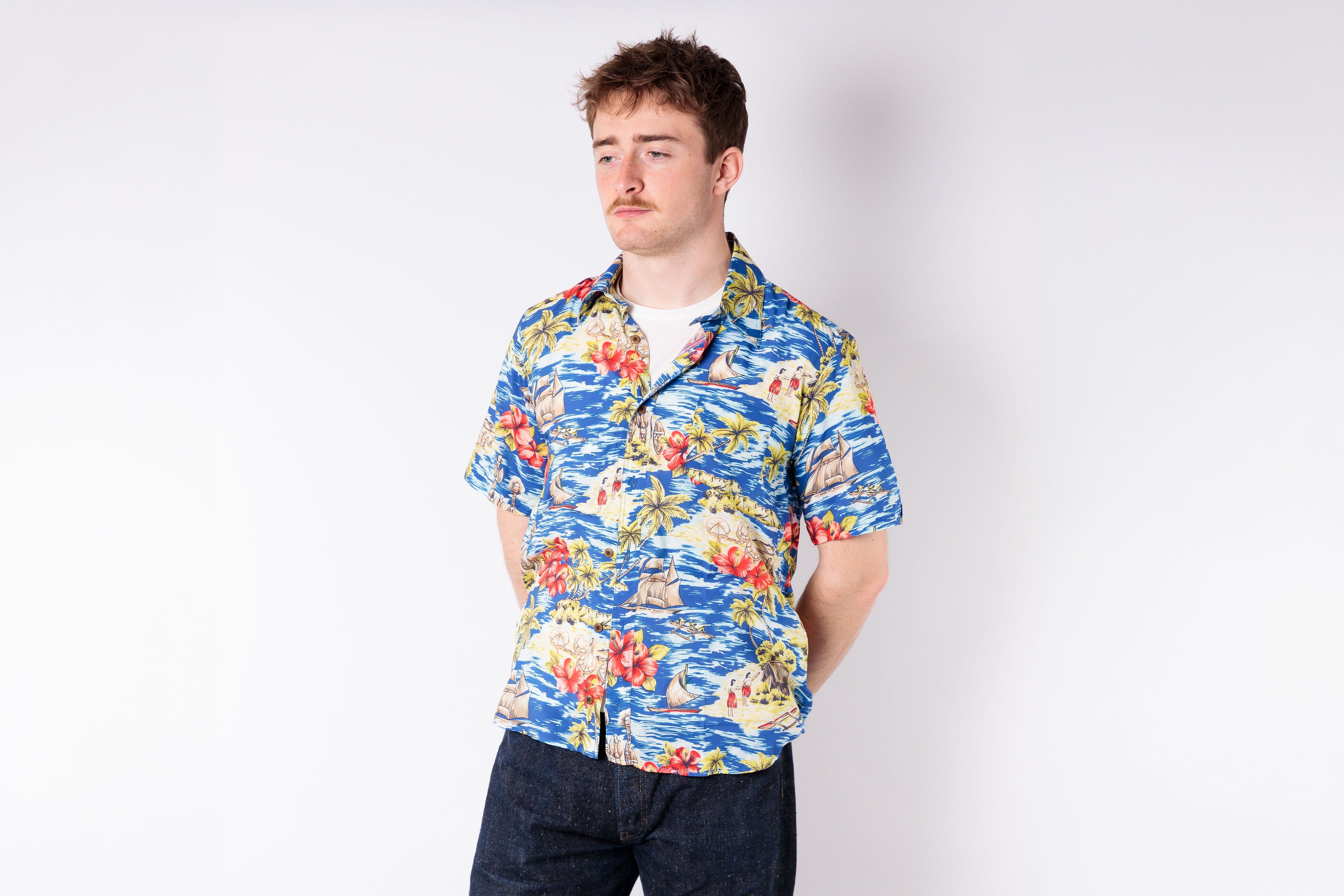 Man wearing a colorful floral shirt on a white background