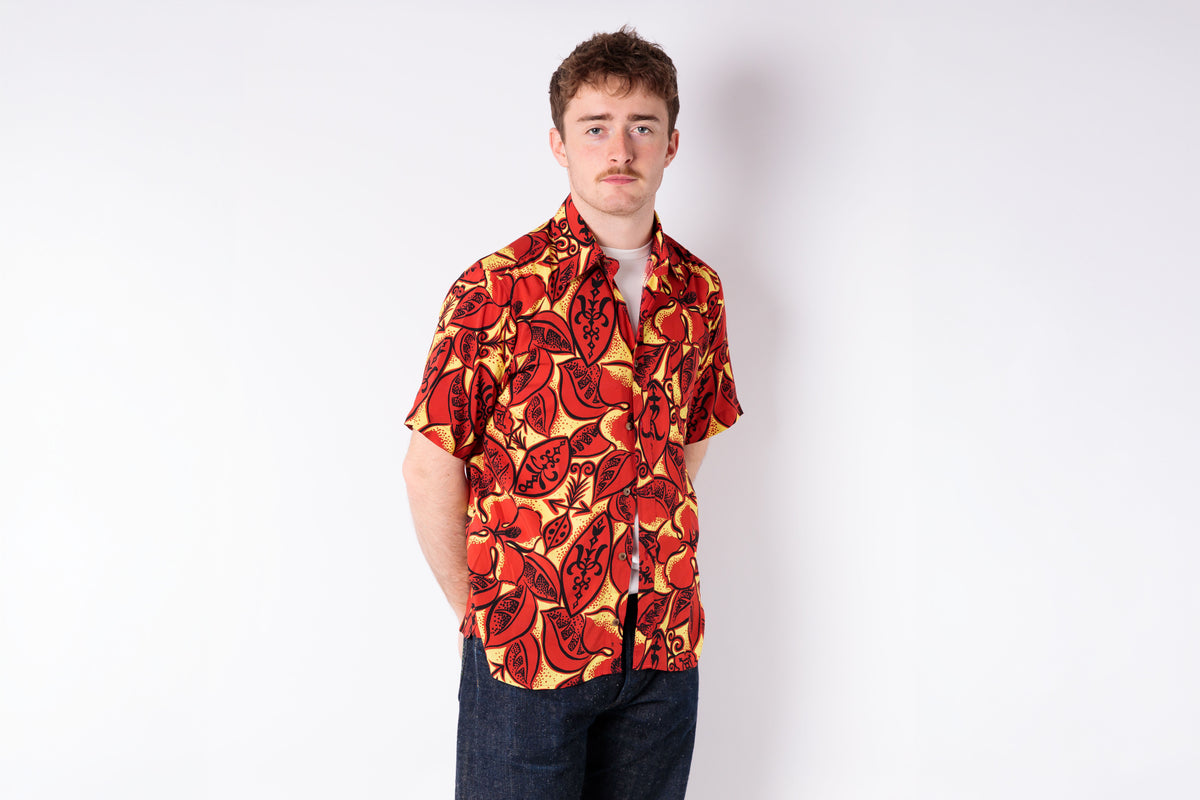 Man wearing a red and yellow patterned shirt on a white background
