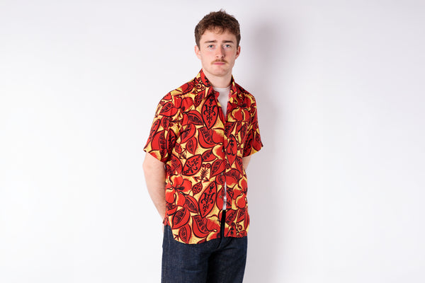 Man wearing a red and yellow patterned shirt on a white background