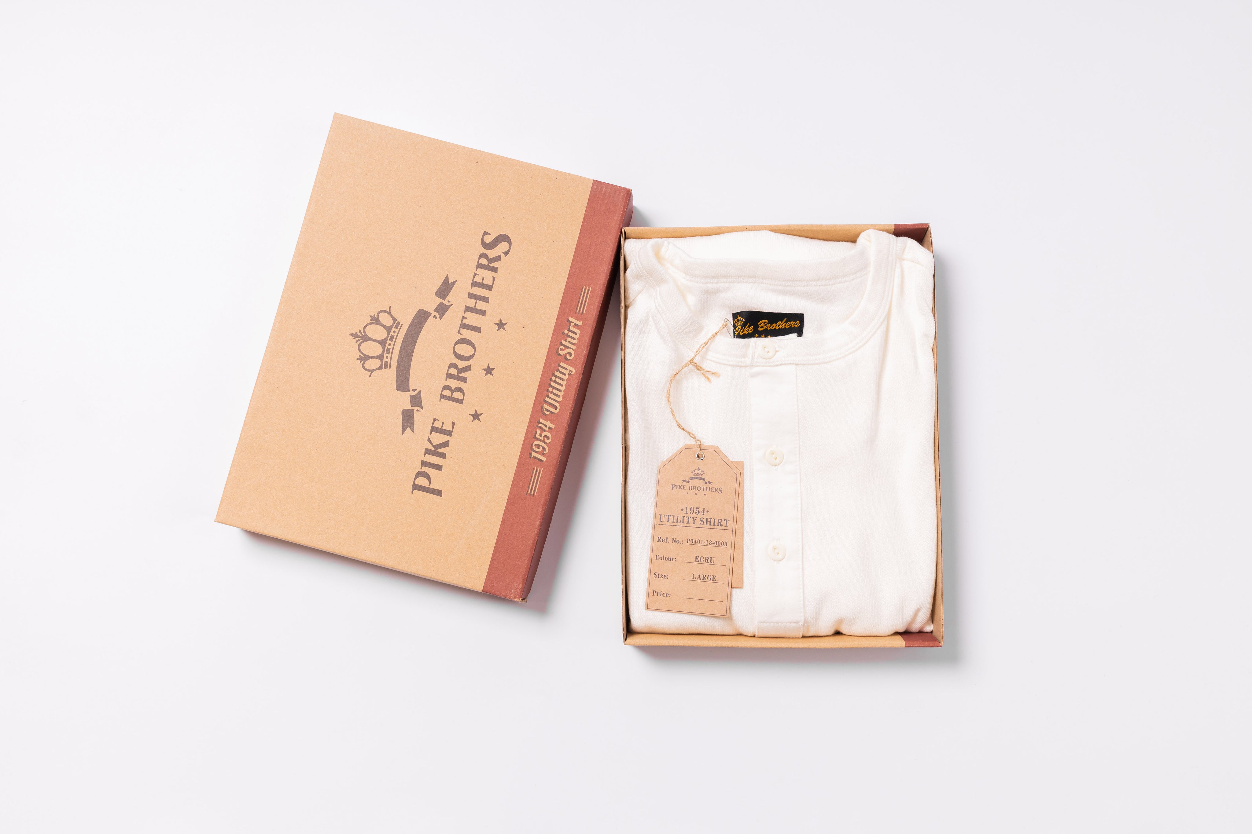 White shirt in an open box with 'Pike Brothers' branding on a light gray background