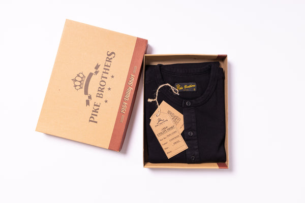 Black shirt in a Pike Brothers box with a tag on a white background