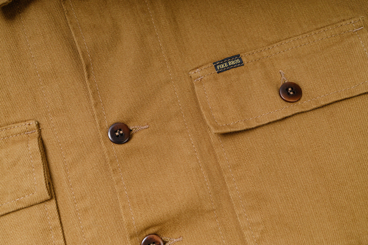 Close-up of a brown jacket with buttons and a brand label.