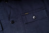 Close-up of a navy blue jacket with a button and pocket detail, featuring the brand 'Pike Bros'.