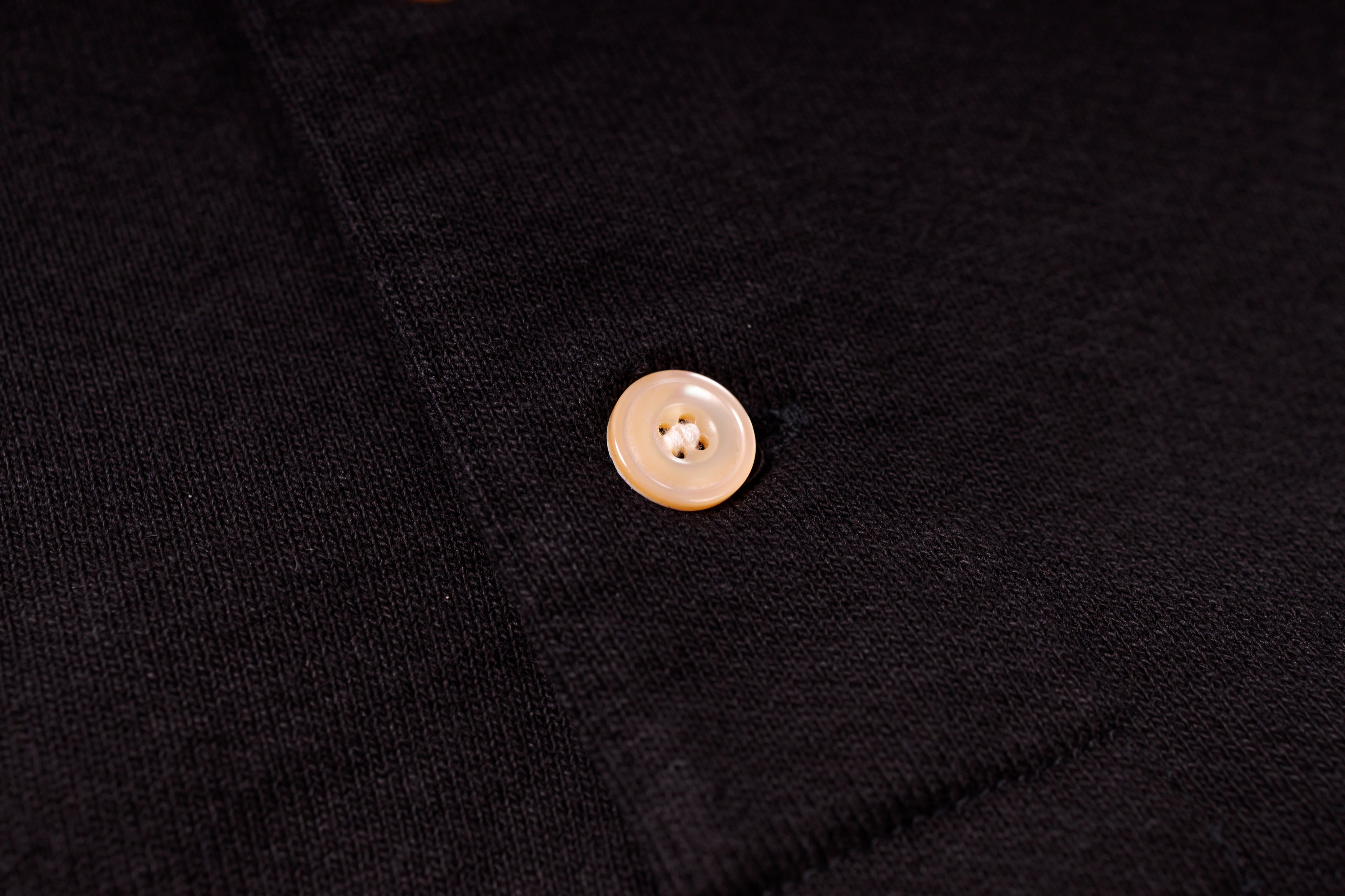 Close-up of a button on a black fabric background