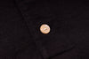 Close-up of a button on a black fabric background