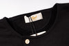 Close-up of a black shirt with a brand label on a white background