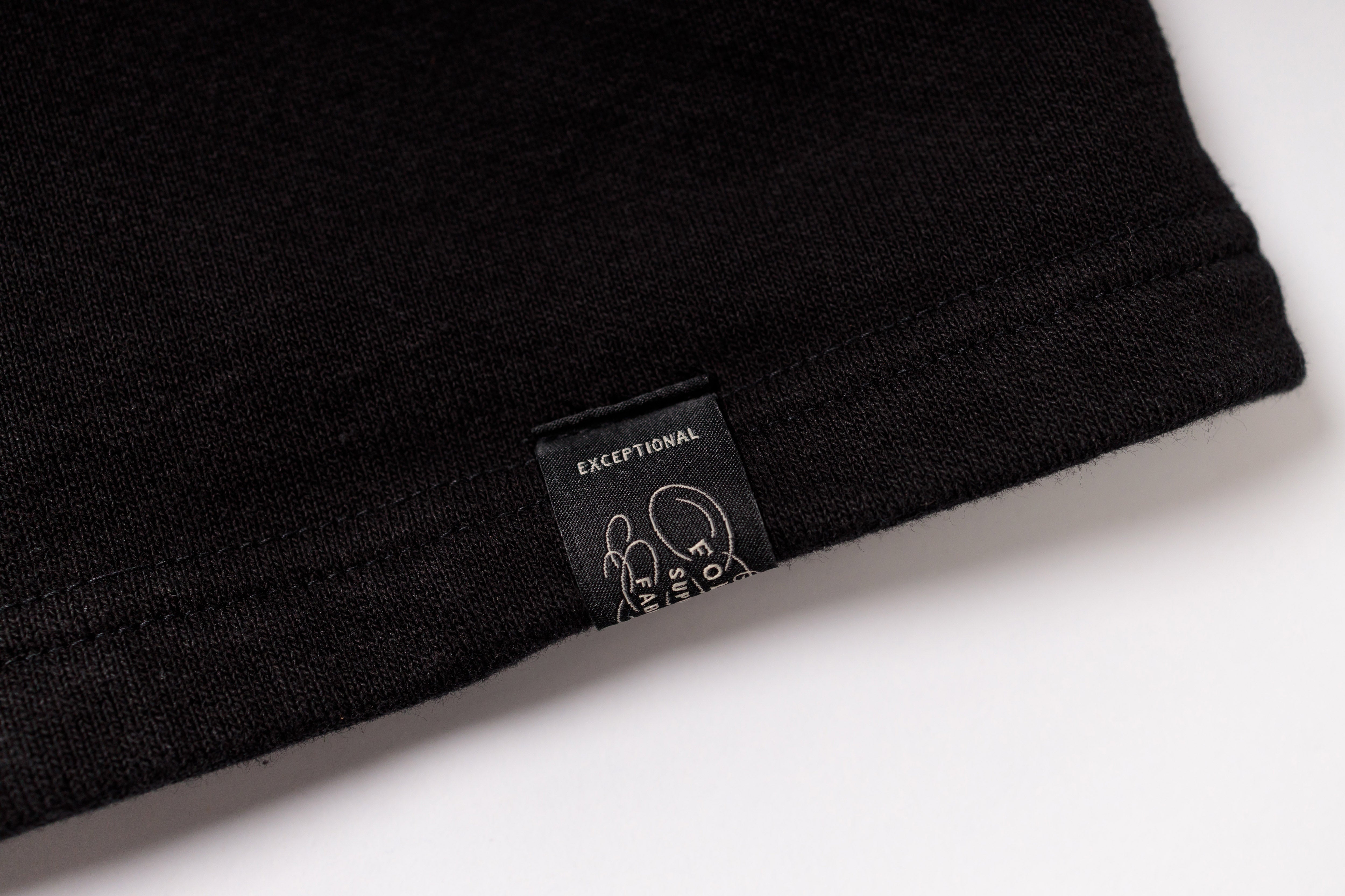 Black t-shirt with a label on a white background